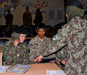 Sgt. Maj. Donna King, Deputy Command-Support Operations, NATO Training Mission Afghanistan’s operations sergeant major, shares photos with the first Afghan National Army females to graduate from Regional Military Training Center-West following their graduation ceremony Jan. 23 at Camp Zafar, Herat, Afghanistan.