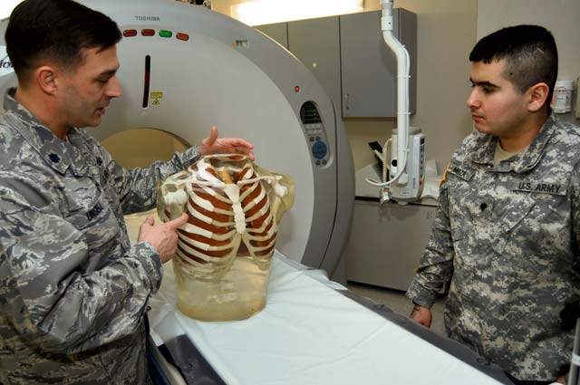 Courtesy photo Lt. Col. Bryan Unsell explains a calibration procedure for the CT scanner to Spc. Yobani Mendoza, a CT technologist.