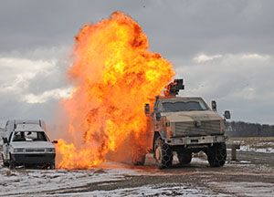 A German army Dingo vehicle drives through a simulated roadside bomb blast during joint training with the 421st Multifunctional Medical Battalion at Baumholder Training Area Feb. 20. This training helps U.S. Army Europe meet its goal of strengthening the interoperability of its partner nation land forces and sets conditions to build coalitions for future overseas contingency operations.