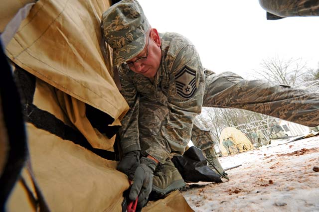 Staff Sgt. Donne Novotny, 48th Civil Engineer Squadron firefighter, hammers a stake for setting up a tent during the Silver Flag training exercise Tuesday on Ramstein. The purpose of Silver Flag is to prepare Airmen for any type of bare-base deployment.