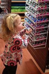 Georgia Tintle, 2, checks out the thread selection at the Kaiserslautern Arts and Cultural Center shop.