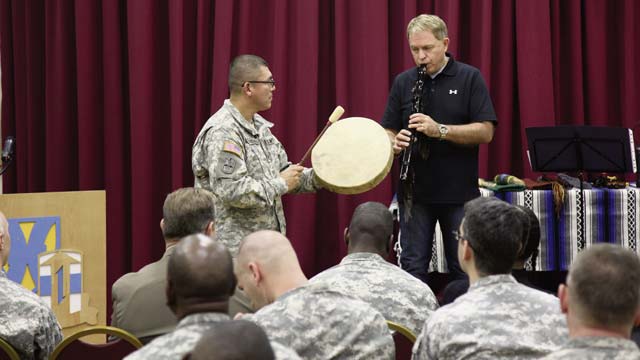 Photo by Sgt. 1st Class Matthew ChlostaStaff Sgt. Carlos Guardardo, Panzer Kaserne installation coordinator from the 21st Special Troops Battalion, 21st Theater Sustainment Command, plays a hand drum in accompaniment with  Kevin Morris, an education technologist at Kaiserslautern Middle School, who plays a musical piece on a Native American style flute during the Native American Heritage Month celebration event Nov. 21 at the Kaiserslautern Community Activities Center.
