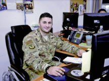 U.S. Air Force Staff Sgt. John Khandzhayan, a protocol liaison for the 86th Airlift Wing, poses for an on-the-job photo after receiving Airlifter of the Week, a wing-level award recognizing Khandzhayan’s outstanding work performance, at Ramstein Air Base, Nov. 19.