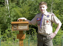 Carter Young, Ramstein Boy Scouts life scout, poses for a photo with his bee hotel at Ramstein Air Base, July 9. Young, his family and the Ramstein Boy Scouts engineered a project to create shelters for solitary bees on the base.