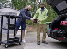 Two Operation Grace Delivery volunteer drivers load meals into the back of a vehicle at Ramstein Air Base, Germany, Sept. 24, 2020. The free meals were delivered to various squadron buildings, homes and dorms on Ramstein as well as Kapaun Air Station. (U.S. Air Force photo by Airman 1st Class Daniel Sanchez)