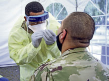 A combat medic at Wiesbaden Army Health Clinic, swabs a patient for COVID-19 testing, June 12.