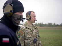 U.S. Air Force Tech. Sgt. Cameron Piontek, right, 435th Contingency Response Squadron air traffic controller, works with a Polish air force air traffic controller as a C-130J Super Hercules aircraft lands in a grass landing zone near Powidz, Poland, Oct. 21, 2020. Throughout 2021 Aviation Detachment Rotation, Airmen from Ramstein Air Base worked with Polish air force personnel by exchanging tactics, techniques and procedures to ultimately increase interoperability. (U.S. Air Force photo by Senior Airman Kristof J. Rixmann)