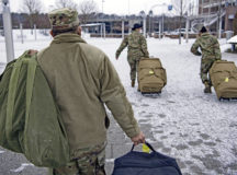 Members of the Deployment Transition Center carry the bags of redeployers at Ramstein Air Base, Germany Feb. 9, 2021. The DTC teaches redeployers about comprehensive fitness which consist of mental, social, physical and spiritual health. (U.S. Air Force photo by Staff Sgt. Kirby Turbak)