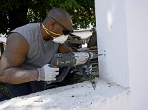 U.S. Air Force Master Sgt. Emmanuel Kamei, 435th Construction and Training Squadron unit deployment manager, drills in brackets for a fence installation during a service project and spiritual retreat in Transylvania, Romania, June 20.