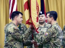 Col. Reid Furman (right), USAG Rheinland-Pfalz commander, passes the unit guidon to Command Sgt. Maj. Raymond Wrensch, incoming command sergeant major, during an Assumption of Responsibility ceremony held at the Armstrong’s Club, Kaiserslautern, Germany, Oct. 19.