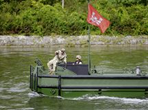 Sgt. Daniel Beltran, a bridge crewmember crew chief assigned to the 809th Multi-Role Bridge Company, gives directions from his M30 Bridge Erection Boat during a bridging equipment field testing exercise on the Danube River in Ingolstadt, Germany, from 12-25 Sept.